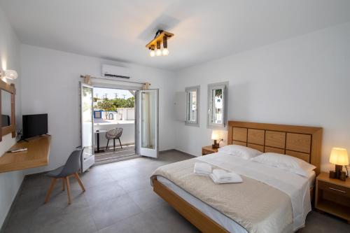 佩里萨Petra Aqua Villa的一间卧室配有一张床、一张书桌和一台电视
