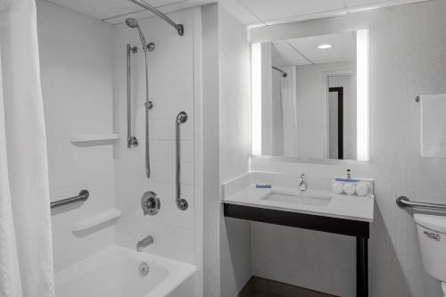 阿什维尔阿什维尔西南部尚品折扣中心区智选假日套房酒店的白色的浴室设有水槽和淋浴。