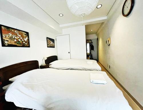 东京☆Cozy Japanese style room☆的一间医院房间,配有两张床和墙上的时钟