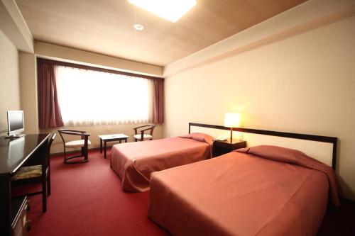 十和田十和田庄酒店的酒店客房设有两张床和窗户。