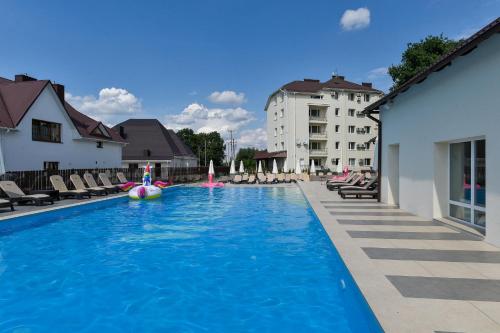 卢茨克Makis Hotel SPA的一个带椅子的大型游泳池和一间酒店