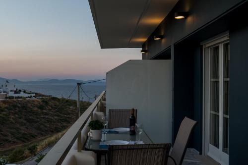 拉斐那CHROMA Lodge Rafina的阳台配有桌子,享有海景。