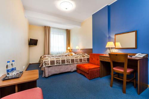 格但斯克奥利维亚酒店 的酒店客房配有一张床、一张桌子和一把椅子。