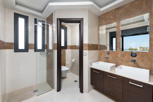 依克希亚Ixia Breeze 3的一间带两个盥洗盆、淋浴和卫生间的浴室