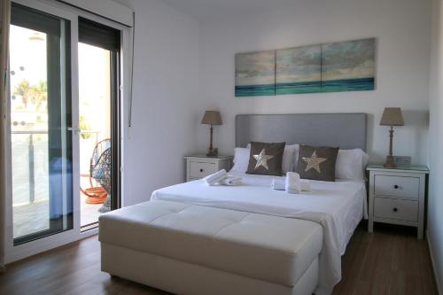 圣米格尔德阿沃纳Villa Golf y Mar的一间带一张白色大床的卧室和一个阳台