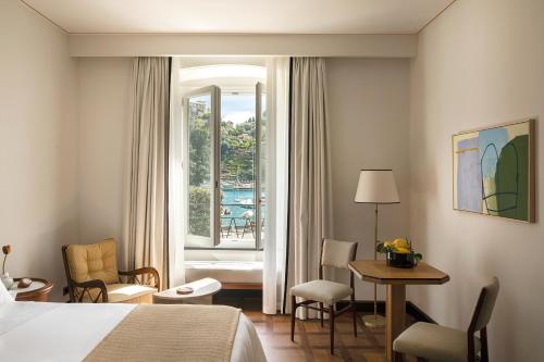 波托菲诺Splendido Mare, A Belmond Hotel, Portofino的酒店客房设有床、桌子和窗户。