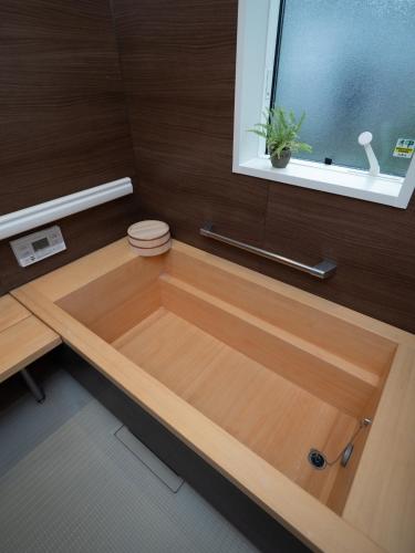 镰仓市Kamakura International House Japanese-style room w Shower Toilette - Vacation STAY 11630的带窗户的浴室内的木制浴缸