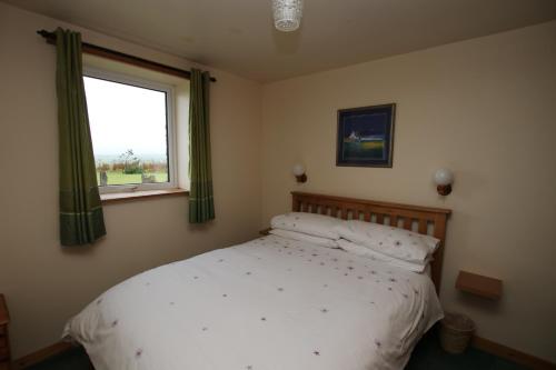 LybsterTaigh An Clachair的卧室配有白色的床和窗户