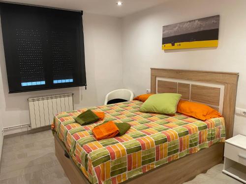 赫罗纳Apartament Margarit的一间卧室配有带橙色和绿色枕头的床