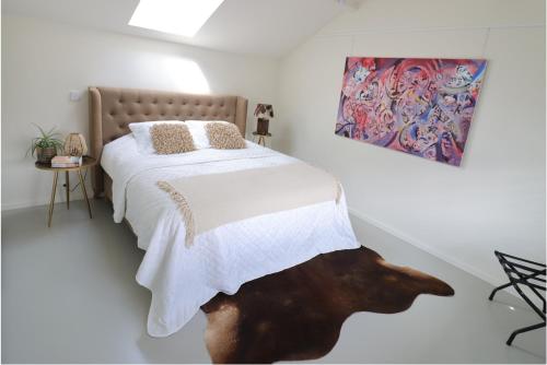 隆德泽尔Louis Henry Loft的卧室配有一张床,墙上挂有绘画作品