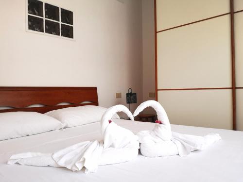 丽都迪奥斯蒂亚Appartamento Jungle Beach的两个白天鹅坐在床上