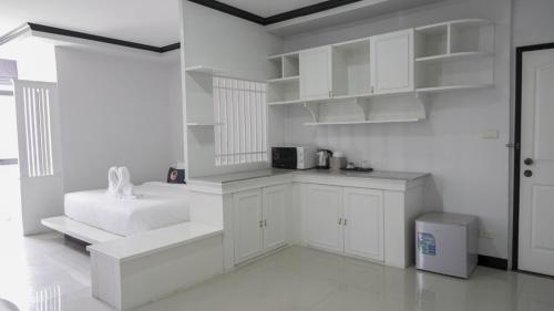 Ban Bang TalatRoomQuest Nichada ISB International的白色的厨房配有白色的橱柜和微波炉