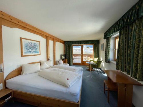 埃尔瓦尔德Hotel Alpin的一间卧室配有两张床和一张书桌