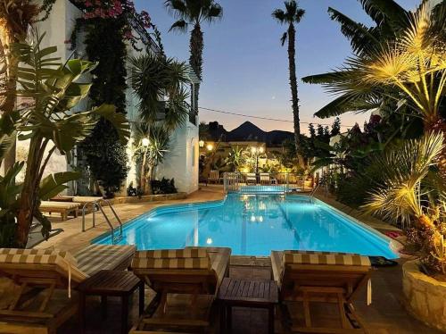 阿默达拉-伊拉克利翁米诺雅公寓酒店的一个带椅子和棕榈树的大型游泳池