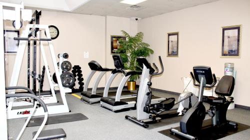 皇后区Marco LaGuardia Hotel & Suites的健身房设有数台跑步机和时钟