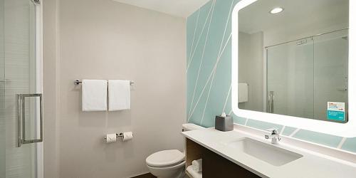 费耶特维尔avid hotel Fayetteville West的一间带水槽、卫生间和镜子的浴室