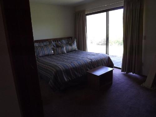 六月湖Rr-edgewater01的一间卧室设有一张床和一个大窗户