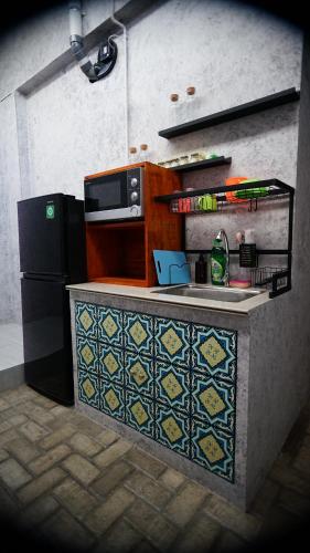 班达亚齐Lala Hostel的厨房配有微波炉和冰箱。