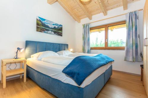 迈斯霍芬Chalet Mandl Sauna Pool Rollstuhlgängig的一间卧室配有一张大床和蓝色床头板
