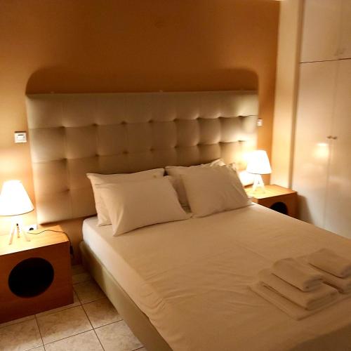美西尼TSELIOS的一间卧室配有一张带两盏灯的大型白色床。