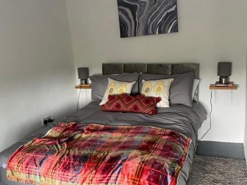 DoocharyBeautiful Thatched Adderwal Cottage Donegal的一间卧室配有一张大床和色彩缤纷的毯子
