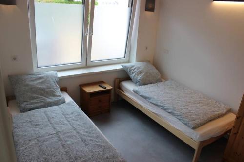 HolleFerienwohnung - Monteurunterkunft 31188 Holle的小房间设有两张床和窗户