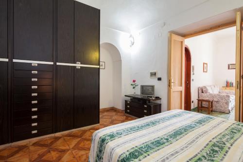 波西塔诺卡萨旺达住宿加早餐旅馆的一间卧室配有一张床、一个橱柜和一台电视