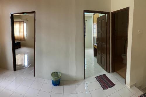 Permatang JanggusAwani Homestay的走廊设有两面镜子,铺有瓷砖地板