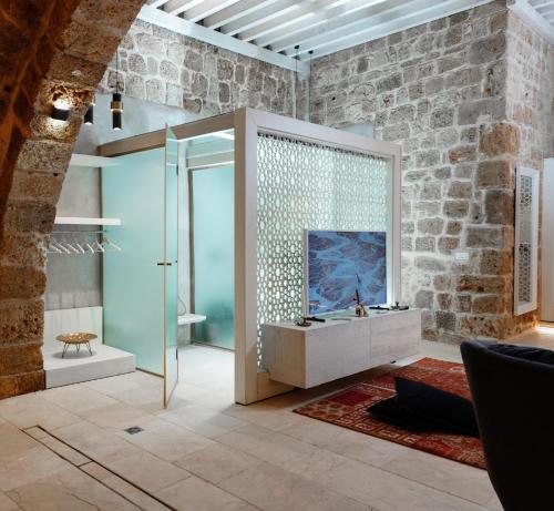 阿卡Dalaa的一间带玻璃淋浴的浴室和一台电视