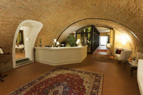 圣米尼亚托圣米尼亚托酒店的一间位于带拱门的建筑中的客厅,楼内有地毯