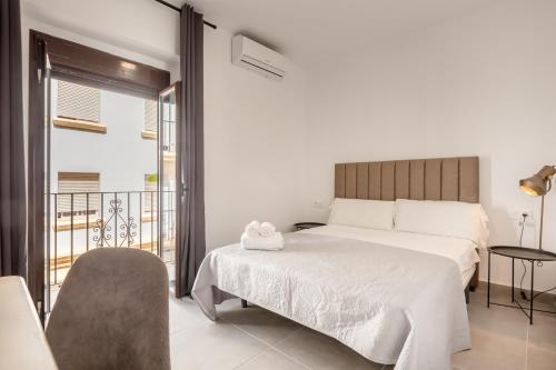 赫雷斯-德拉弗龙特拉Villamarta Boutique Rooms的一间卧室设有一张床和一个阳台