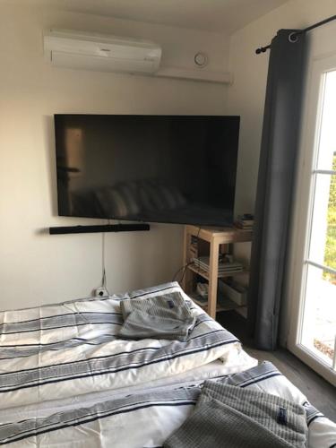 LöberödMariannelund Bed&Beer的卧室配有一张壁挂式平面电视的床。
