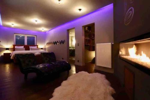 MontsEl nido Malaika-Villa privative的一间紫色灯光卧室、一张床和地毯