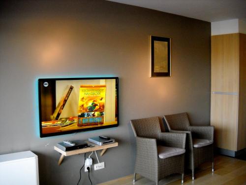 布列登劳特莱克公寓的一间设有两把椅子和壁挂式平面电视的房间