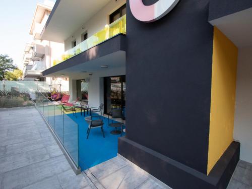 里米尼Demo Hotel Design Emotion的一座拥有蓝色和黄色墙壁和椅子的建筑