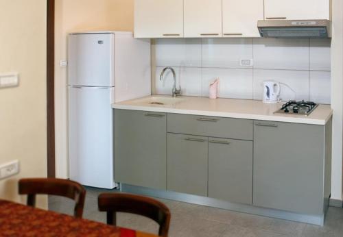 海法港口酒店的厨房配有白色冰箱和桌子