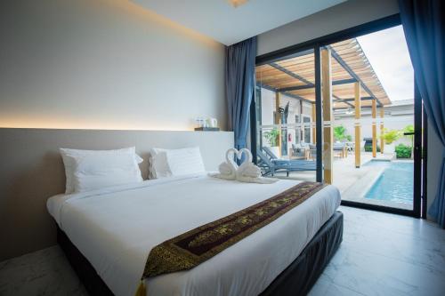 邦涛海滩Gold Chariot Pool Villa, Phuket - SHA Plus Certified的一间卧室设有一张大床和一个大窗户