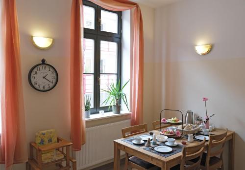 瓦伦Hotel Waren-Alte Warener Zeitung的一间设有桌子和墙上时钟的餐厅