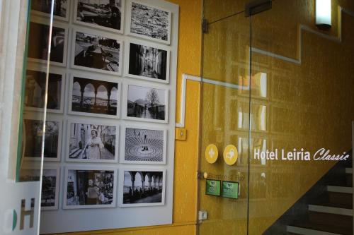 莱里亚莱里亚经典酒店的墙上有照片的房间和玻璃门
