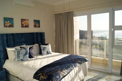 斯科特堡Luxury Apartment 23 @ Seahorse with 180° seaview的一间卧室设有一张床和一个大窗户