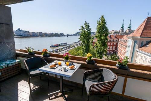 布达佩斯多瑙河明珠精品公寓的河景阳台配有桌椅