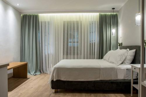 克桑西Isidorou Suite Xanthi的一间卧室配有一张带绿色窗帘的大床