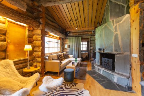 萨利色尔卡Kuukkeli Log Houses Teerenpesä - Premium Suite A48的小木屋内带壁炉的客厅