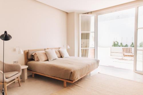 塞维利亚Plácido y Grata的一间白色卧室,配有床和阳台