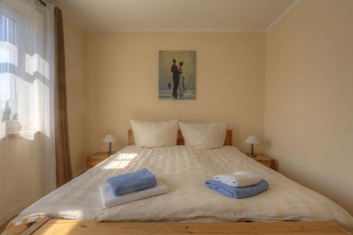 伯尔格伦德-雷特维施伯尔格伦德海滩公寓酒店的一间卧室配有一张床,上面有两条毛巾