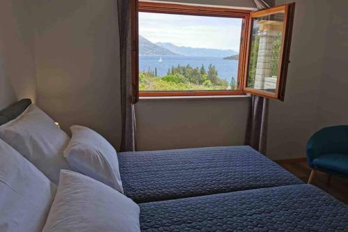 科尔丘拉Deluxe apartman “ Koromačna”的一间卧室设有一张床和一个美景窗户。
