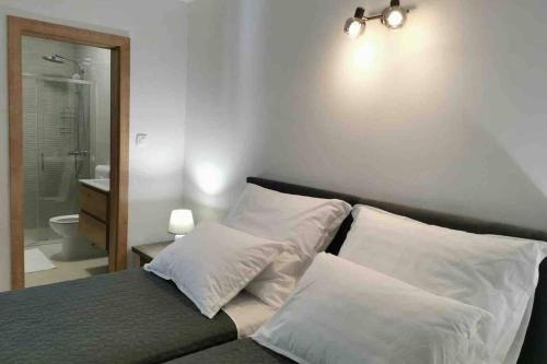 科尔丘拉Deluxe apartman “ Koromačna”的一间卧室配有带白色枕头的床和一间浴室
