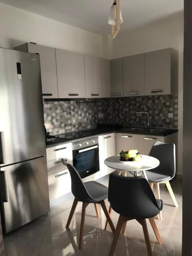 伊古迈尼察Cyclops Luxury Apartments的厨房配有桌椅和冰箱。