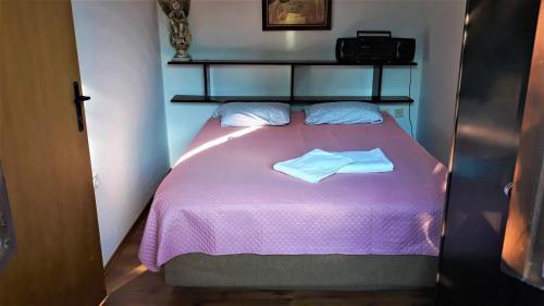 塞尼Apartment Modric的一间小卧室,配有一张紫色的床和两条毛巾