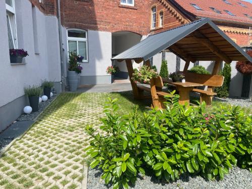 爱尔福特Ferienwohnungen in Erfurt的一个带木桌和长凳的花园
